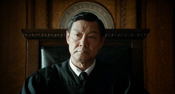 Movie still from “Big Eyes” (2014), directed by Tim Burton – An older man wearing a black robe in a court room; Close Up shot, Low angle