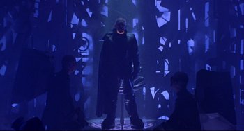 Movie still from “Bill & Ted's Bogus Journey” (1991), directed by Peter Hewitt – A man standing in the middle of a room with two other men; Wide shot, Low angle
