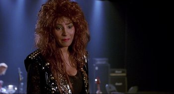 Movie still from “Bill & Ted's Bogus Journey” (1991), directed by Peter Hewitt – A woman in a black jacket and red wig; Close Up shot, Over the shoulder angle