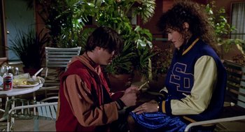 Movie still from “Bill & Ted's Bogus Journey” (1991), directed by Peter Hewitt – A man and a woman looking at a cell phone; Medium shot, High angle