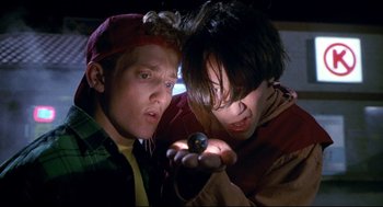 Movie still from “Bill & Ted's Bogus Journey” (1991), directed by Peter Hewitt – Two young men looking at a cell phone in a dark room; Close Up shot, Low angle