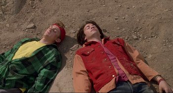 Movie still from “Bill & Ted's Bogus Journey” (1991), directed by Peter Hewitt – Two young men are laying on the ground together; Medium shot, Overhead angle