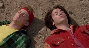Movie still from “Bill & Ted's Bogus Journey” (1991), directed by Peter Hewitt – Two young men are laying on the ground together; Close Up shot, Overhead angle