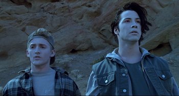 Movie still from “Bill & Ted's Bogus Journey” (1991), directed by Peter Hewitt – Two young men standing next to each other in front of a cliff; Medium shot, Low angle