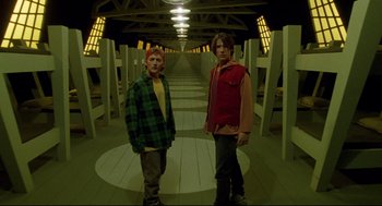 Movie still from “Bill & Ted's Bogus Journey” (1991), directed by Peter Hewitt – Two young men standing next to each other in a hallway; Wide shot, Low angle