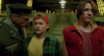 Movie still from “Bill & Ted's Bogus Journey” (1991), directed by Peter Hewitt – A group of men standing next to each other in a hallway; Medium shot, Low angle