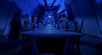 Movie still from “Bill & Ted's Bogus Journey” (1991), directed by Peter Hewitt – A group of people sitting at a table in a dark room; Wide shot, High angle