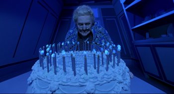 Movie still from “Bill & Ted's Bogus Journey” (1991), directed by Peter Hewitt – An older woman is looking at a cake with candles; Medium shot, Overhead angle