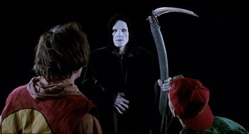 Movie still from “Bill & Ted's Bogus Journey” (1991), directed by Peter Hewitt – A man in a black robe holding a scythe; Medium shot, Over the shoulder angle