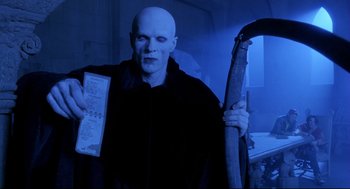 Movie still from “Bill & Ted's Bogus Journey” (1991), directed by Peter Hewitt – A man dressed as voldemort holding a book; Medium shot, Low angle