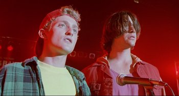 Movie still from “Bill & Ted's Bogus Journey” (1991), directed by Peter Hewitt – Two young men standing next to each other in front of a microphone; Close Up shot, Low angle