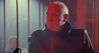 Movie still from “Bill & Ted's Bogus Journey” (1991), directed by Peter Hewitt – An older man wearing a black jacket and a red scarf; Close Up shot, Low angle