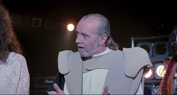 Movie still from “Bill & Ted's Bogus Journey” (1991), directed by Peter Hewitt – An older man with a beard wearing a paper costume; Close Up shot, Over the shoulder angle