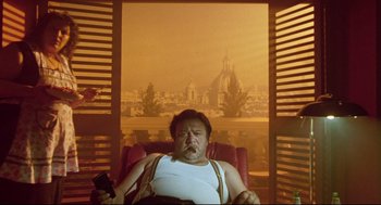 Movie still from “Bill & Ted's Bogus Journey” (1991), directed by Peter Hewitt – A man sitting in a chair holding a television remote; Medium shot, Low angle