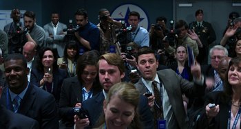 Movie still from “Billy Lynn's Long Halftime Walk” (2016), directed by Ang Lee – A group of people standing around each other with microphones in front of them; Medium shot, Over the shoulder angle