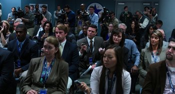 Movie still from “Billy Lynn's Long Halftime Walk” (2016), directed by Ang Lee – A group of people sitting in front of microphones in a room; Medium shot, High angle