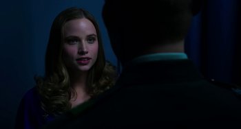 Movie still from “Billy Lynn's Long Halftime Walk” (2016), directed by Ang Lee – A young woman looking at a man in a suit in front of a blue wall; Close Up shot, Over the shoulder angle