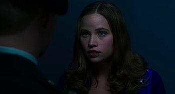Movie still from “Billy Lynn's Long Halftime Walk” (2016), directed by Ang Lee – A young woman stares into the camera with a serious look on her face; Close Up shot, Over the shoulder angle