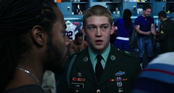 Movie still from “Billy Lynn's Long Halftime Walk” (2016), directed by Ang Lee – A man in a uniform talking to another man in a room; Medium shot, Over the shoulder angle