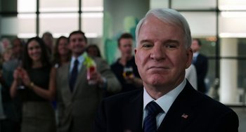 Movie still from “Billy Lynn's Long Halftime Walk” (2016), directed by Ang Lee – A man in a suit and tie in front of a group of people; Medium shot, Over the shoulder angle