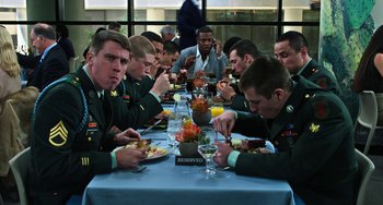 Movie still from “Billy Lynn's Long Halftime Walk” (2016), directed by Ang Lee – A group of men sitting at a table eating food; Medium shot, Over the shoulder angle