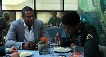 Movie still from “Billy Lynn's Long Halftime Walk” (2016), directed by Ang Lee – Two men sitting at a table with a plate of food in front of them; Medium shot, Over the shoulder angle
