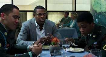 Movie still from “Billy Lynn's Long Halftime Walk” (2016), directed by Ang Lee – A group of people sitting at a table with food; Medium shot, Over the shoulder angle