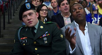 Movie still from “Billy Lynn's Long Halftime Walk” (2016), directed by Ang Lee – A group of people in a crowd of people watching something; Medium shot, Over the shoulder angle
