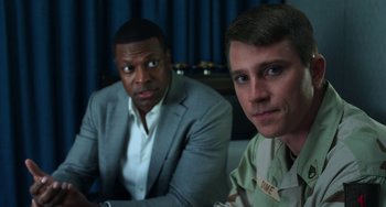 Movie still from “Billy Lynn's Long Halftime Walk” (2016), directed by Ang Lee – Two men sitting next to each other in front of a curtain; Close Up shot, Over the shoulder angle