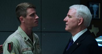 Movie still from “Billy Lynn's Long Halftime Walk” (2016), directed by Ang Lee – A man and a man in a suit and tie standing next to each other; Close Up shot, Over the shoulder angle