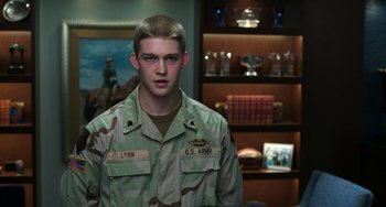 Movie still from “Billy Lynn's Long Halftime Walk” (2016), directed by Ang Lee – A young man in a military fatigues standing in a room; Medium shot, Over the shoulder angle