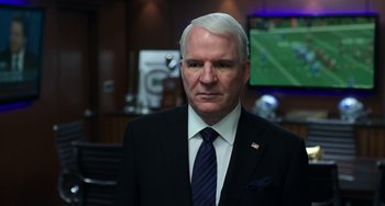 Movie still from “Billy Lynn's Long Halftime Walk” (2016), directed by Ang Lee – A man in a suit and tie in front of a television; Close Up shot, Over the shoulder angle