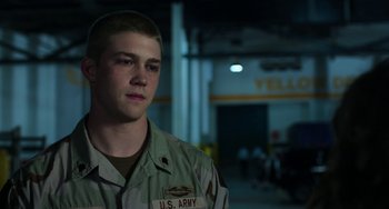 Movie still from “Billy Lynn's Long Halftime Walk” (2016), directed by Ang Lee – A man in a military uniform standing in a garage; Close Up shot, Over the shoulder angle