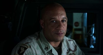 Movie still from “Billy Lynn's Long Halftime Walk” (2016), directed by Ang Lee – A man in military fatigues sitting in front of a building; Close Up shot, High angle