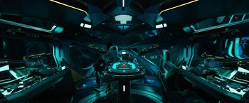 Movie still from “Black Adam” (2022), directed by Jaume Collet-Serra – A man standing next to a table in a room; Extreme Wide shot, Overhead angle