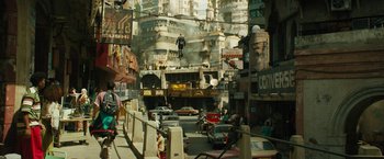 Movie still from “Black Adam” (2022), directed by Jaume Collet-Serra – A street scene with a man hanging upside down from a building; Extreme Wide shot, High angle