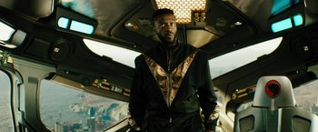 Movie still from “Black Adam” (2022), directed by Jaume Collet-Serra – A man standing in the middle of a room; Medium shot, Low angle