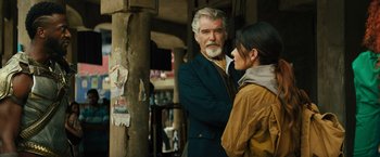 Movie still from “Black Adam” (2022), directed by Jaume Collet-Serra – An older man standing next to a young woman; Medium shot, Over the shoulder angle