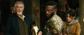 Movie still from “Black Adam” (2022), directed by Jaume Collet-Serra – A man in a costume holding a gold helmet; Close Up shot, Over the shoulder angle