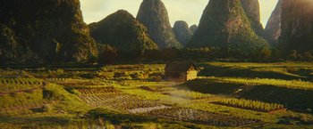 Movie still from “Black Adam” (2022), directed by Jaume Collet-Serra – A small house in the middle of a green field; Extreme Wide shot, High angle