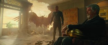 Movie still from “Black Adam” (2022), directed by Jaume Collet-Serra – A man standing next to a bunch of animals in a room; Medium shot, Low angle