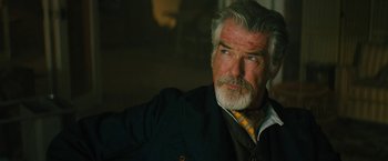 Movie still from “Black Adam” (2022), directed by Jaume Collet-Serra – An older man with a gray beard wearing a suit and tie; Close Up shot, Over the shoulder angle