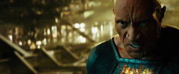 Movie still from “Black Adam” (2022), directed by Jaume Collet-Serra – An older man is looking down at a piece of food; Close Up shot, Low angle