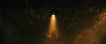 Movie still from “Black Adam” (2022), directed by Jaume Collet-Serra – A light shining down on the floor of an old building; Extreme Wide shot, Overhead angle