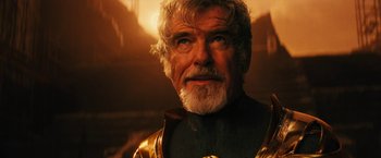 Movie still from “Black Adam” (2022), directed by Jaume Collet-Serra – An older man with a white beard wearing a gold jacket; Close Up shot, Over the shoulder angle