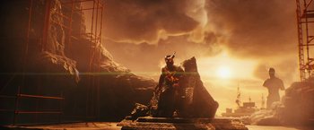 Movie still from “Black Adam” (2022), directed by Jaume Collet-Serra – A man standing on top of a rock in front of a mountain; Extreme Wide shot, Low angle