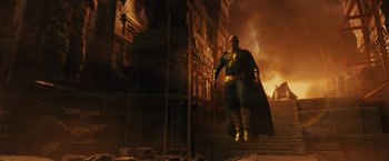Movie still from “Black Adam” (2022), directed by Jaume Collet-Serra – A man with a cape and mask is walking down the stairs; Wide shot, Low angle