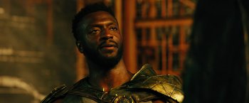 Movie still from “Black Adam” (2022), directed by Jaume Collet-Serra – A man in a costume is looking to his left; Close Up shot, Low angle