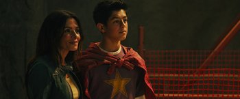 Movie still from “Black Adam” (2022), directed by Jaume Collet-Serra – A young man and woman dressed as superheroes; Close Up shot, Over the shoulder angle