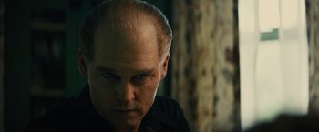 Movie still from “Black Mass” (2015), directed by Scott Cooper – A man with a bald head looking into the camera; Close Up shot, Low angle